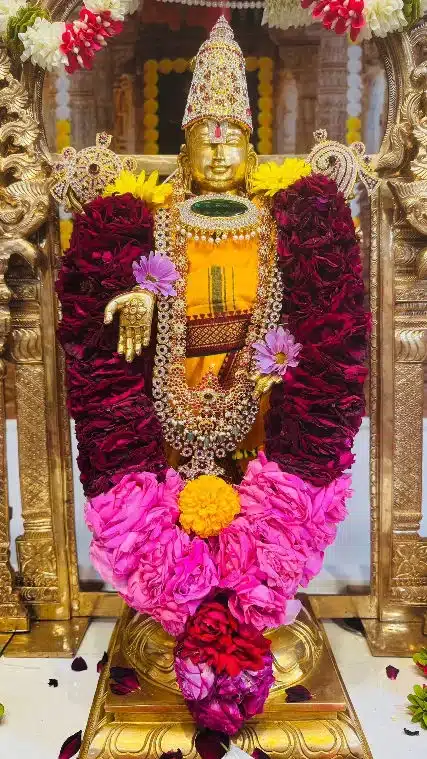 Deity adorned with rose garlands – HTSNM Flower Seva Temple deity adorned with red rose garlands and marigolds